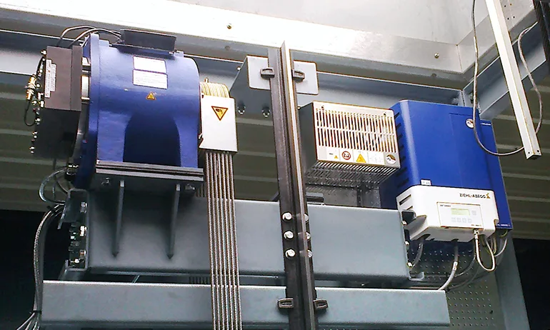 Ziehl-Abegg ZAsyn gearless machine and ZAdyn drive mounted at the top of an elevator shaft — machine-room-less configuration